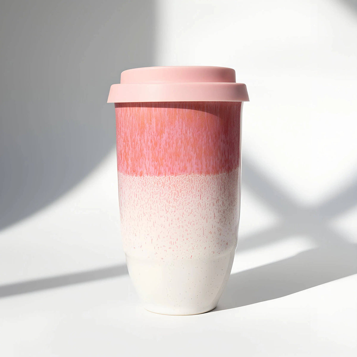 Two-toned pink and white ceramic cup on a light background