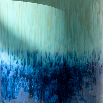 Abstract textured wall art featuring a vertical gradient from a pale mint green top section with subtle woodgrain-like streaks to a deep blue and navy lower section with a brushstroke or flame-like effect.