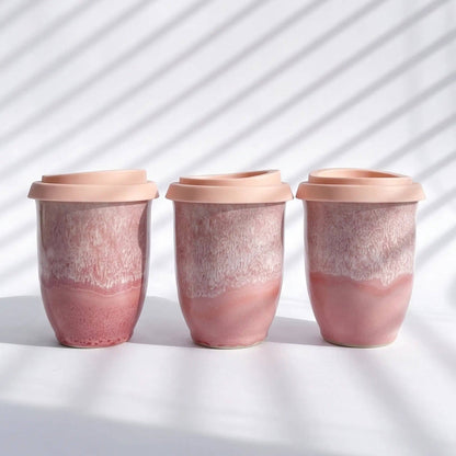 Three pink ceramic cups with a gradient effect on a white background