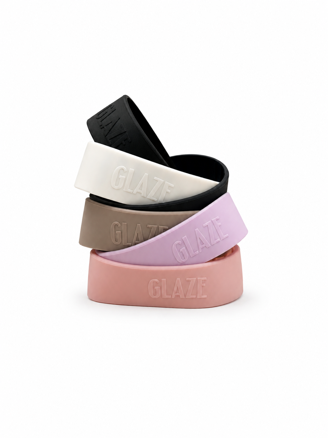 Four silicone bands in black, white, taupe, and pastel pink, stacked on a white background. Each band features the brand name 'GLAZE' embossed on the front.