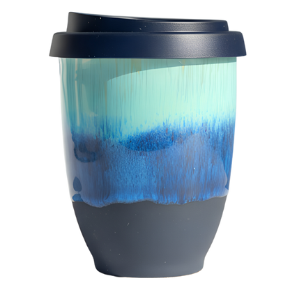 A reusable ceramic travel mug with a dark gray silicone base, a blue and mint green gradient body, and a dark gray lid, shown on a plain white background.