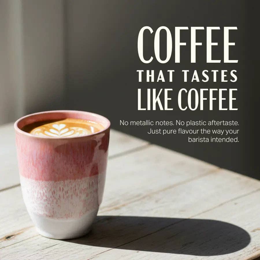 A ceramic coffee cup with a pink and white marbled design sits on a light wooden table, casting a shadow. Large white text on the right reads 'COFFEE THAT TASTES LIKE COFFEE' with smaller descriptive copy below.