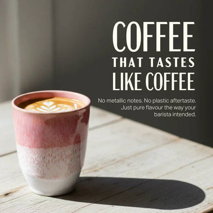 A ceramic coffee cup with a pink and white marbled design sits on a light wooden table, casting a shadow. Large white text on the right reads 'COFFEE THAT TASTES LIKE COFFEE' with smaller descriptive copy below.