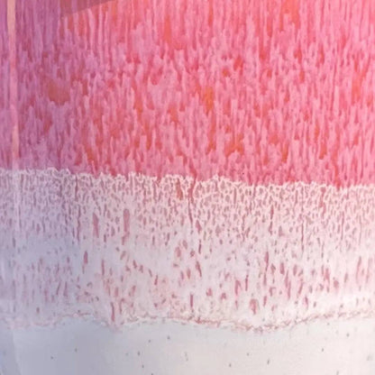 A close-up of a translucent pink and white textured surface, likely a cosmetic container or material swatch, with a horizontal band of lighter pink and white texture below.