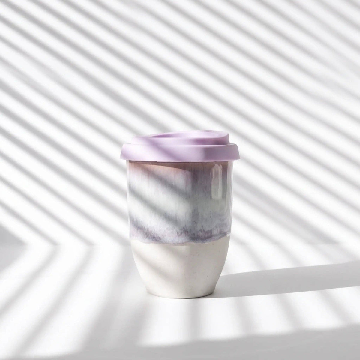 Marbled purple and white tumbler on a light background