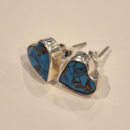 Silver earring with blue stone on a white background